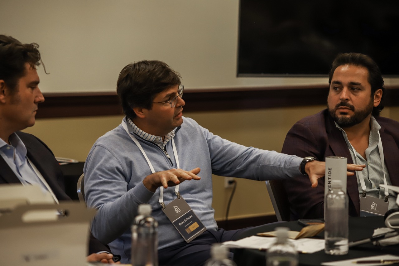 A sector roundtable of leaders sharing best practices around a table.