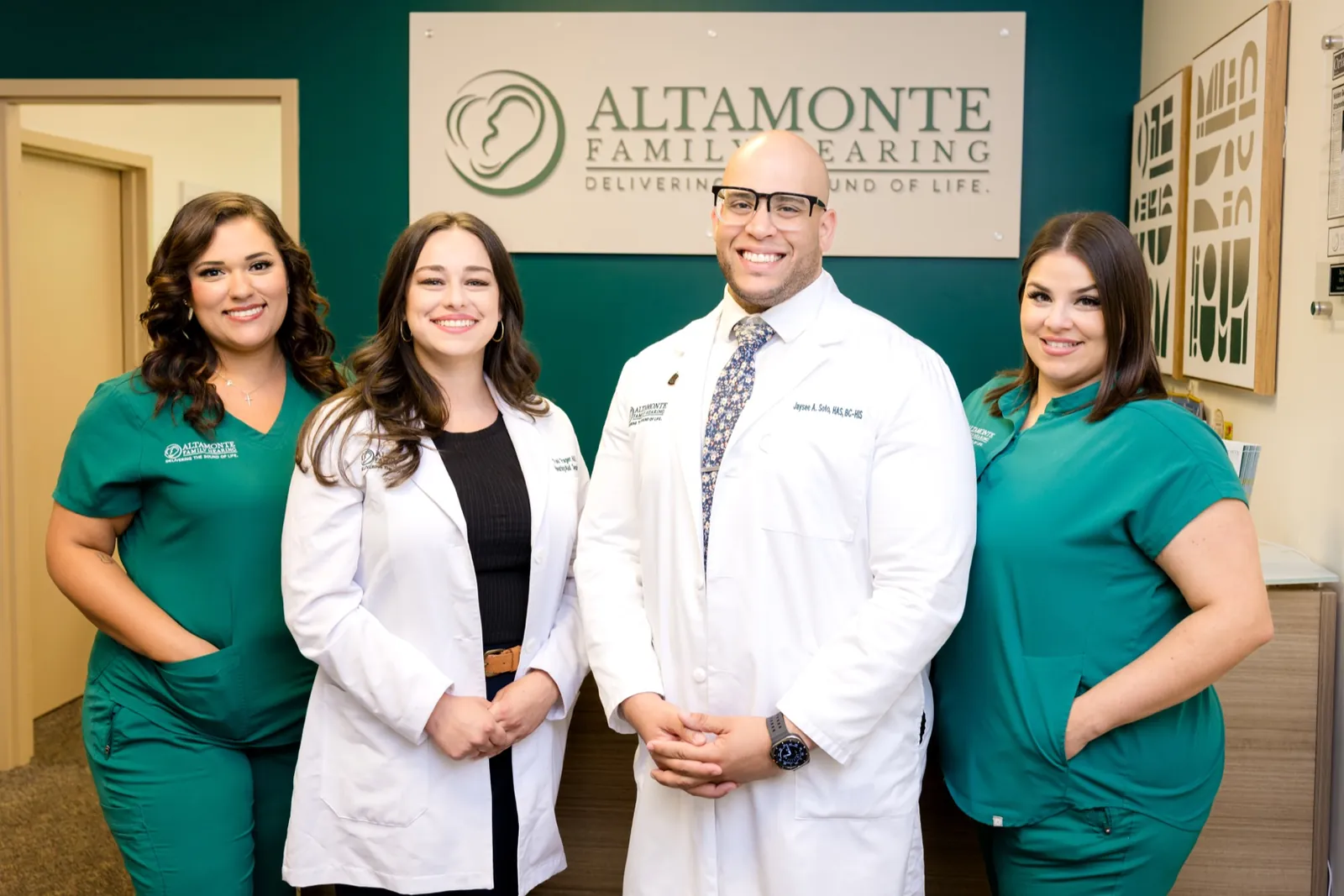 The four-member Altamonte Family Hearing team smiling together at the practice