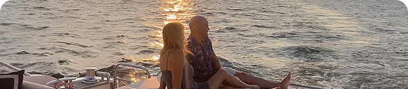 Allan and Nicole Blain sitting side by side on a yacht at sunset, looking out over the water—symbolizing peace, purpose, and shared vision.