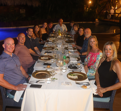 Allan and Nicole Blain host a dinner gathering with friends or teammates, seated around a long table under evening lights, symbolizing community, faith, and intentional connection.