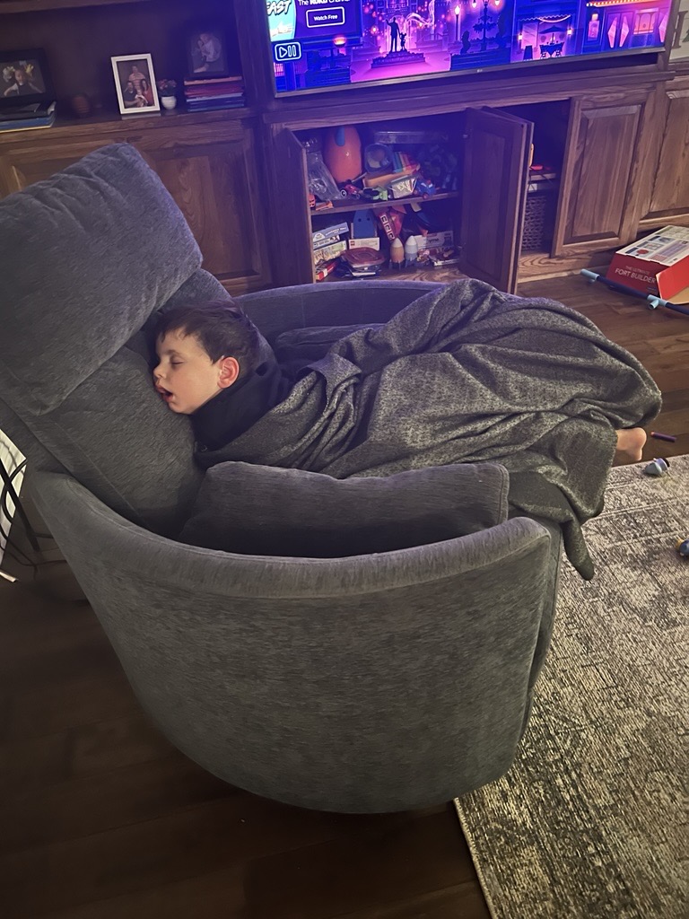 a young boy sleeping hard in a chair