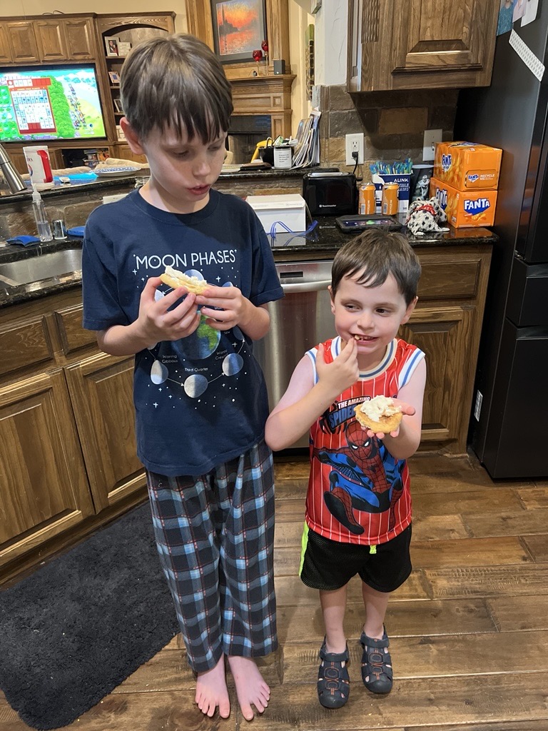 two boys eating icing off a cookie