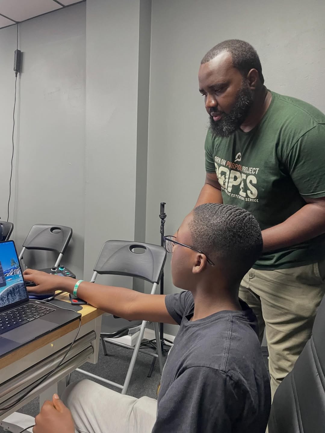 Youth participant learning podcast production and media skills with a R.O.P.E.S. mentor during Podcast On Purpose, a mentorship and youth development program hosted by The Born On Purpose Project in collaboration with Big Brothers Big Sisters of Broward County.