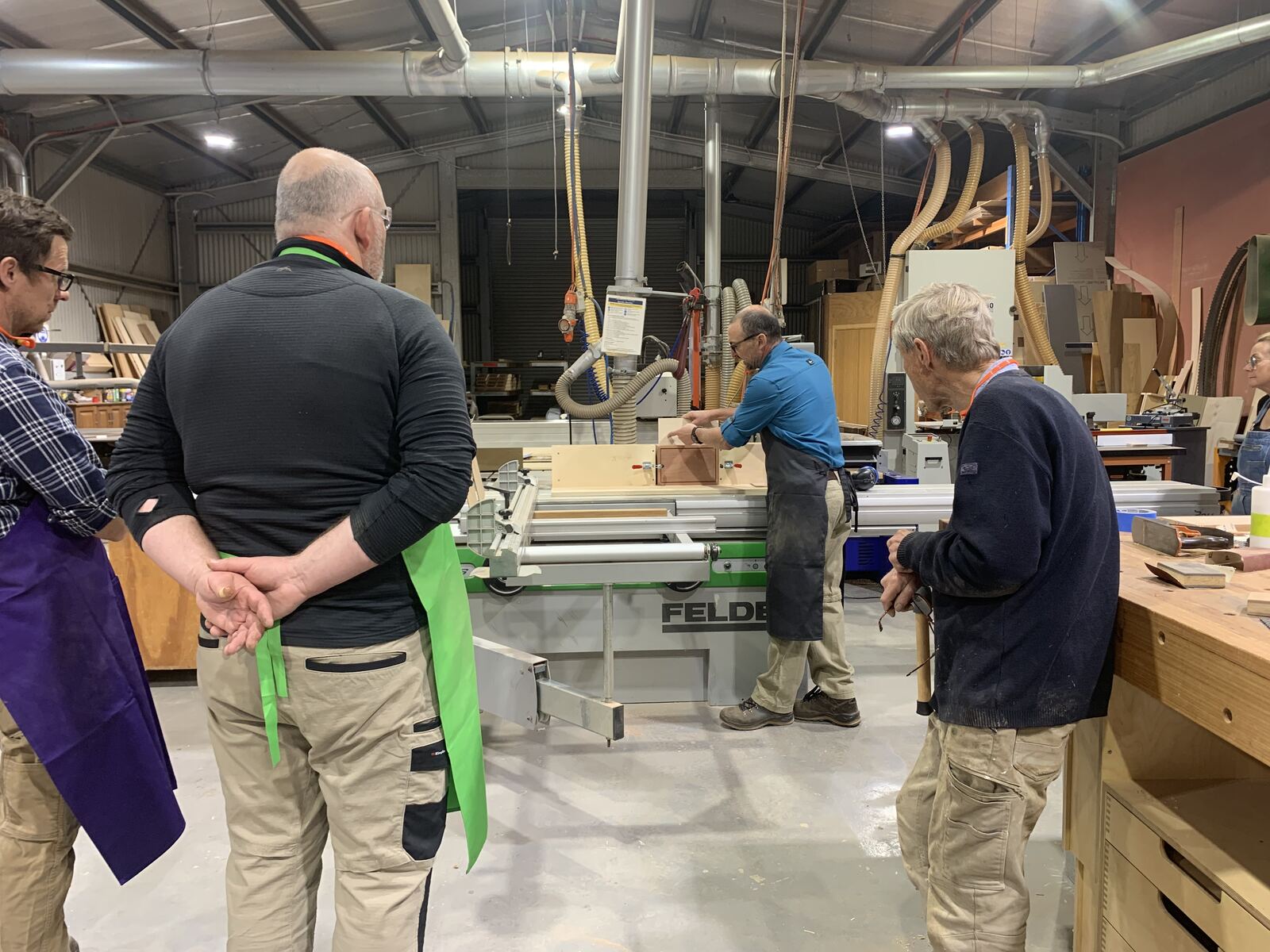 Gino demonstrating the panel saw while the class watches