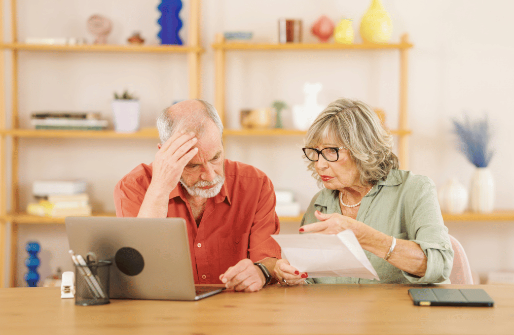 Senior couple worried about finances while reading documents at home Senior couple worried about finances while reading documents at home