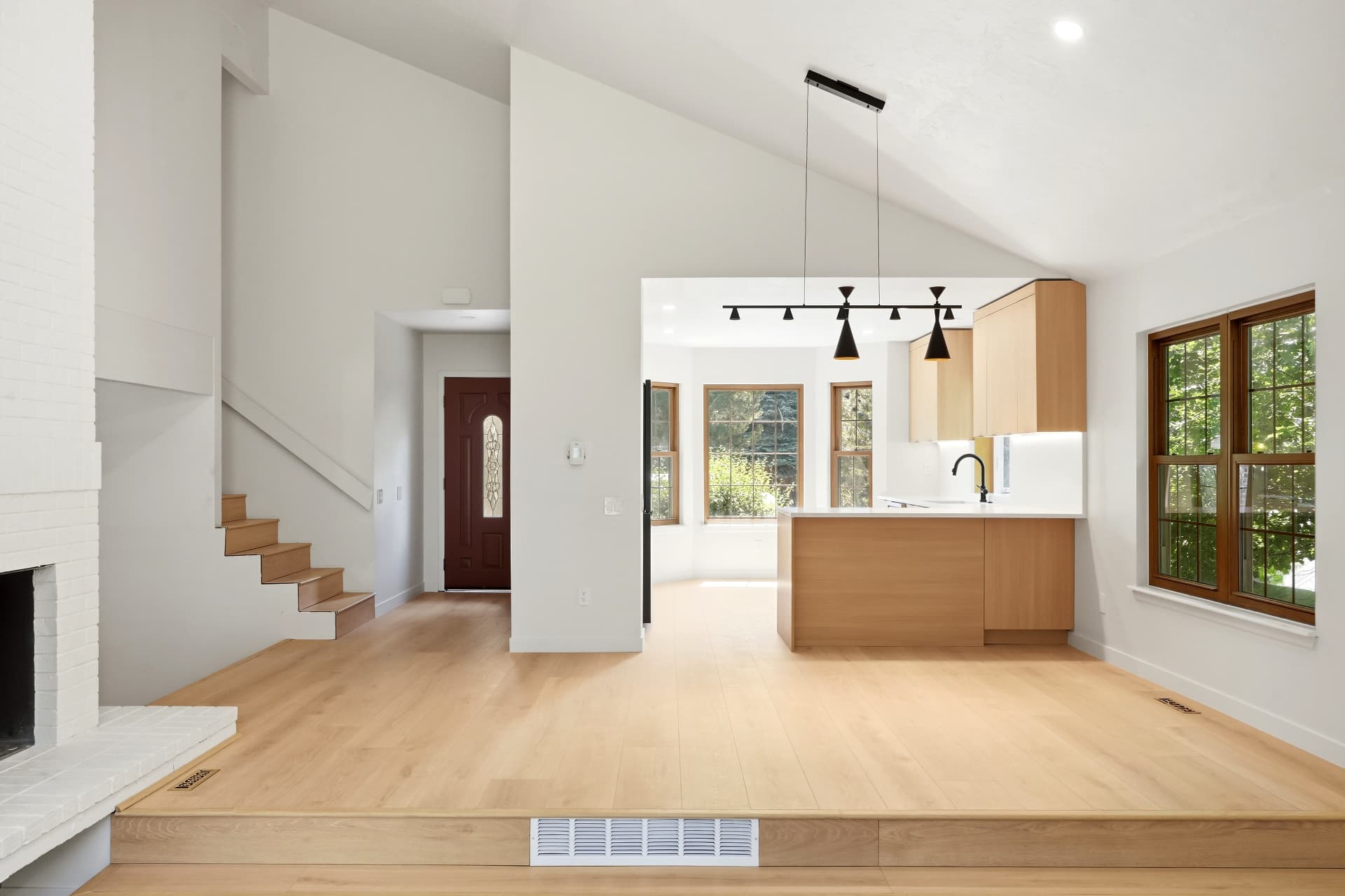 Vaulted living space opening into a remodeled kitchen with oak island