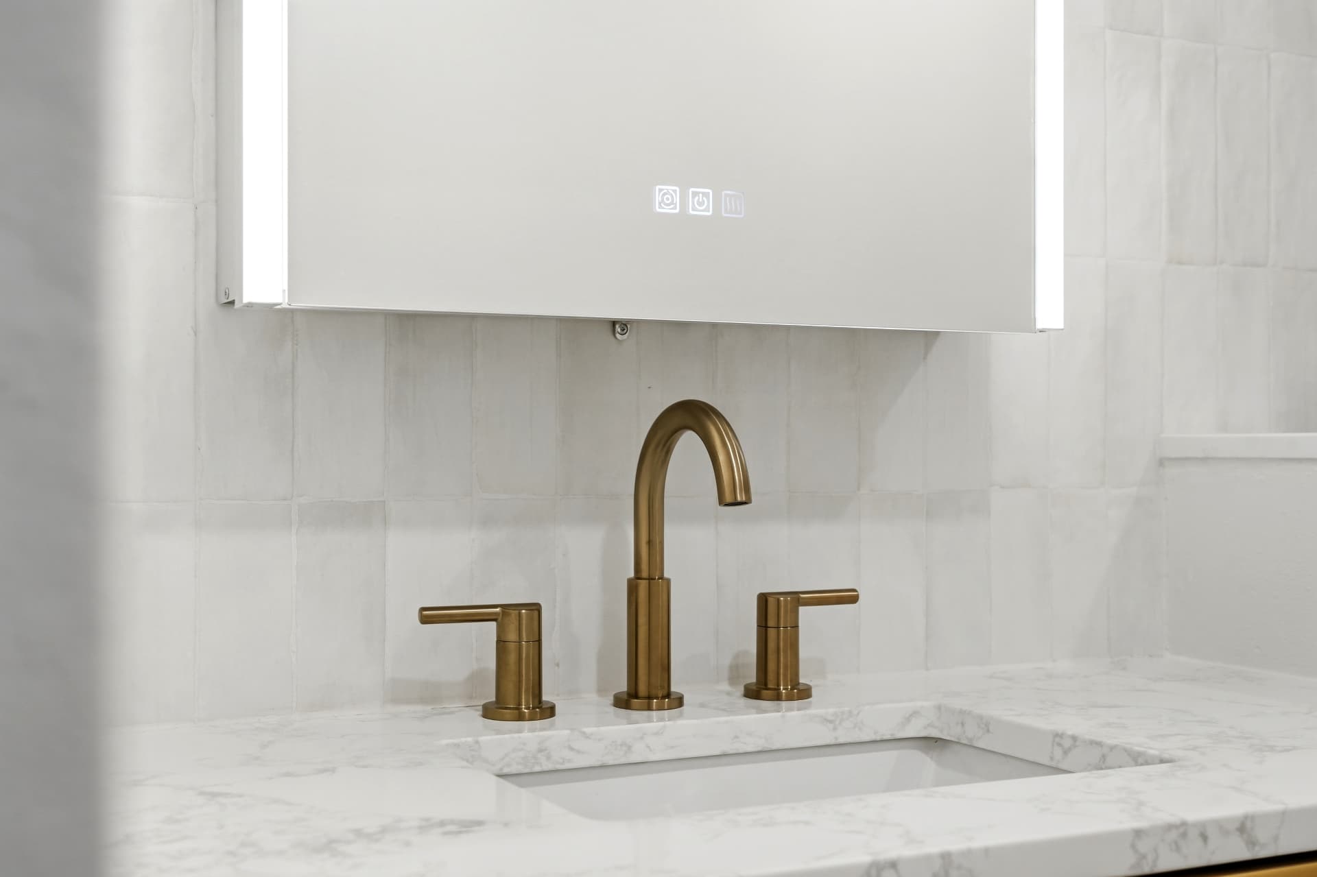 Marble vanity top with widespread brushed gold faucet and backlit LED mirror