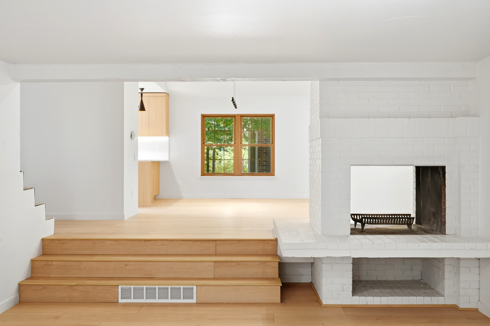 Painted white brick fireplace wall with white oak steps and hearth