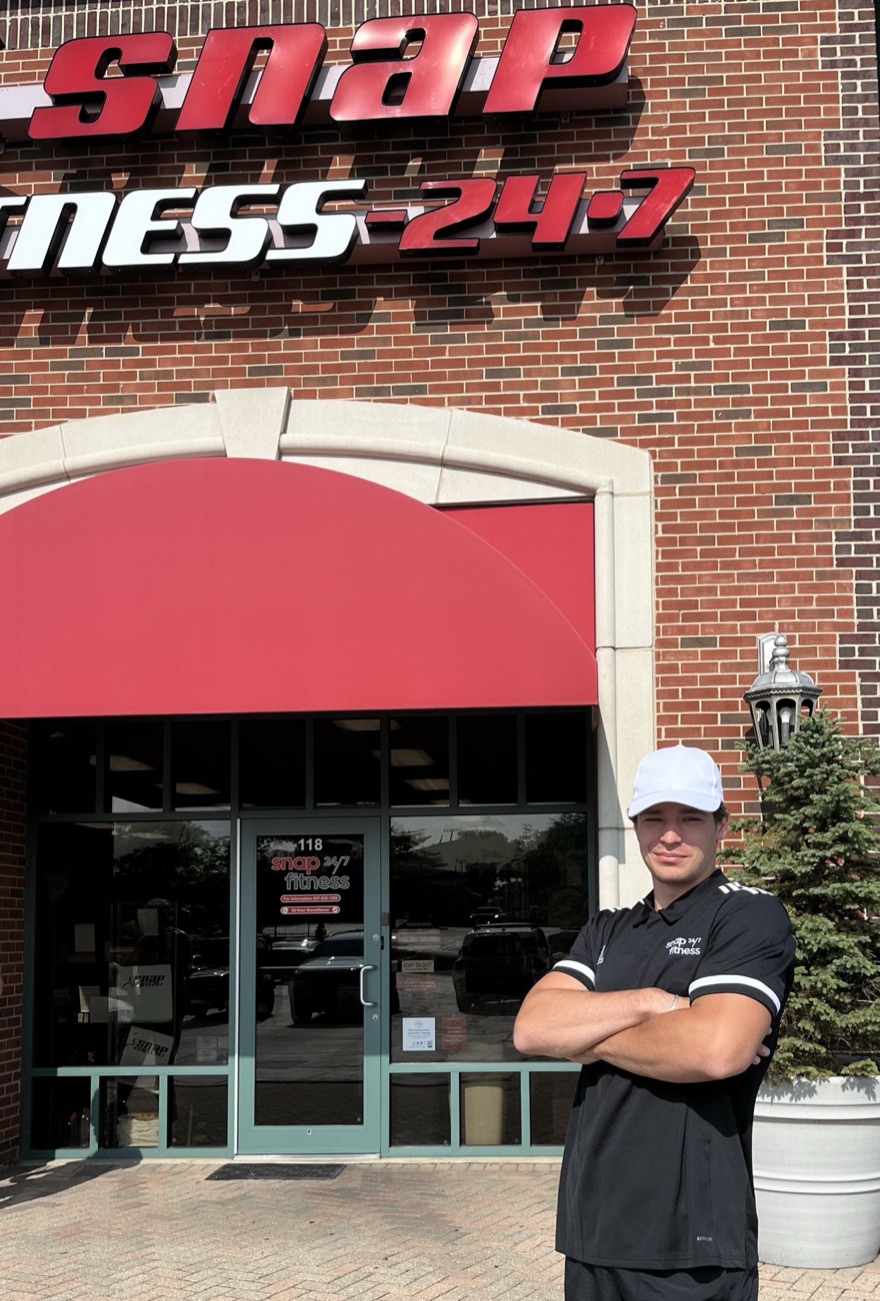 Chad in a staff shirt outside the gym where he did in-person personal training