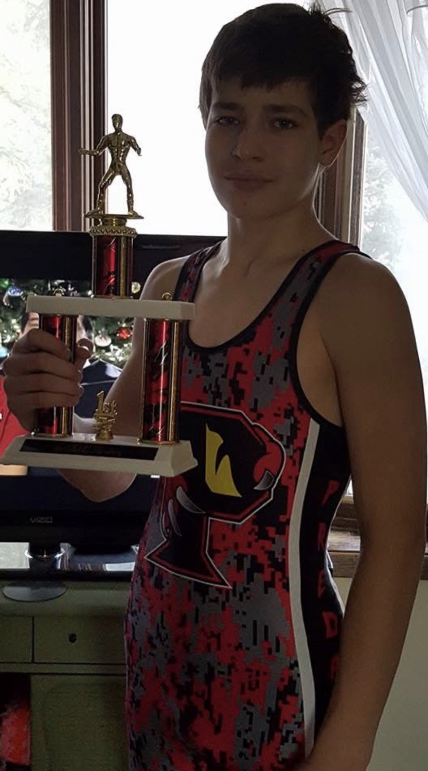 Young Chad holding a first place wrestling trophy