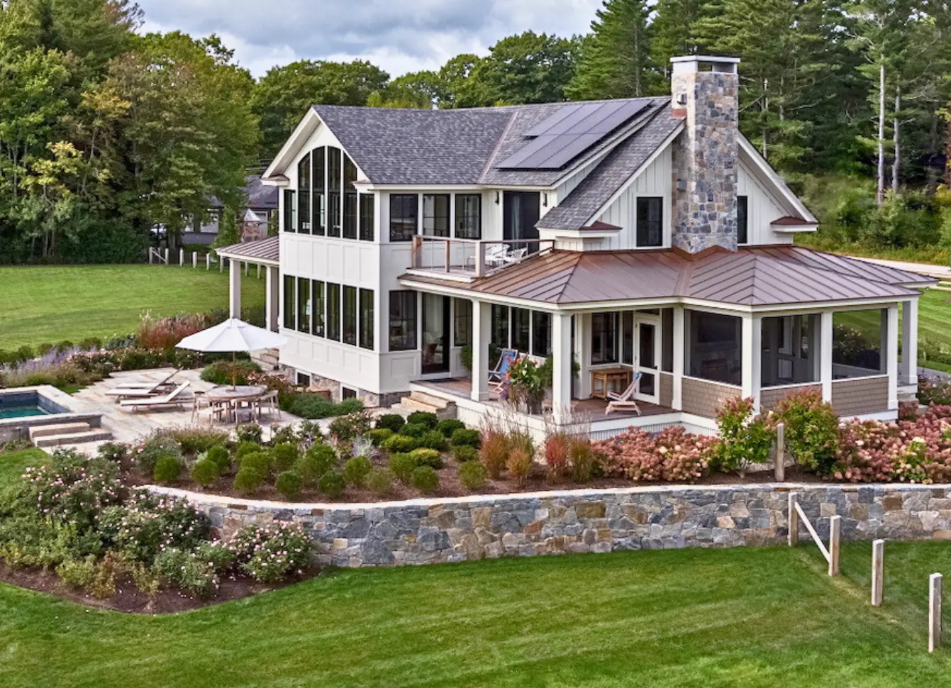 Exterior house painting by Minute Men Painters in Portsmouth, New Hampshire featuring a modern hillside home with fresh siding and trim