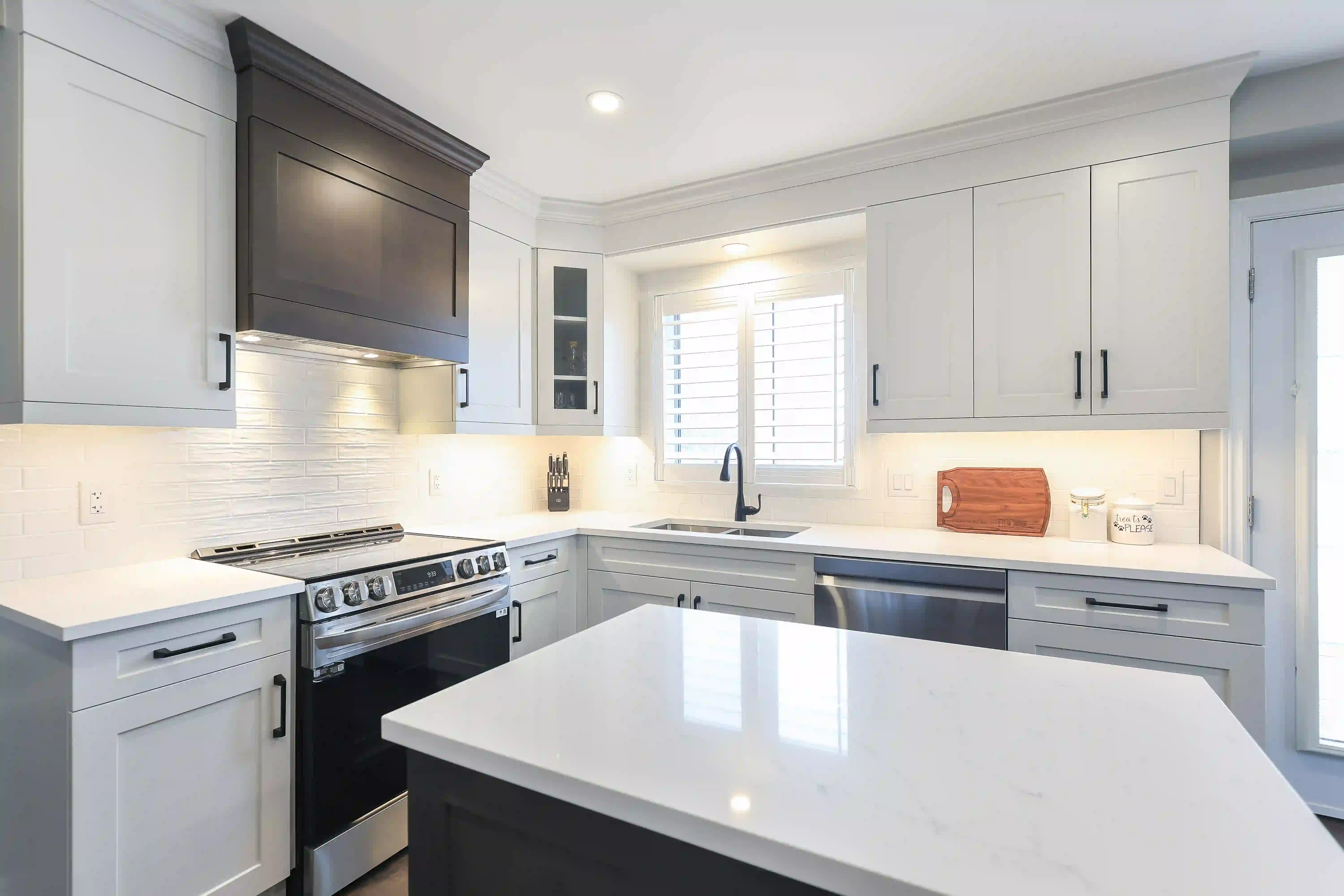 White kitchen with dark island and range