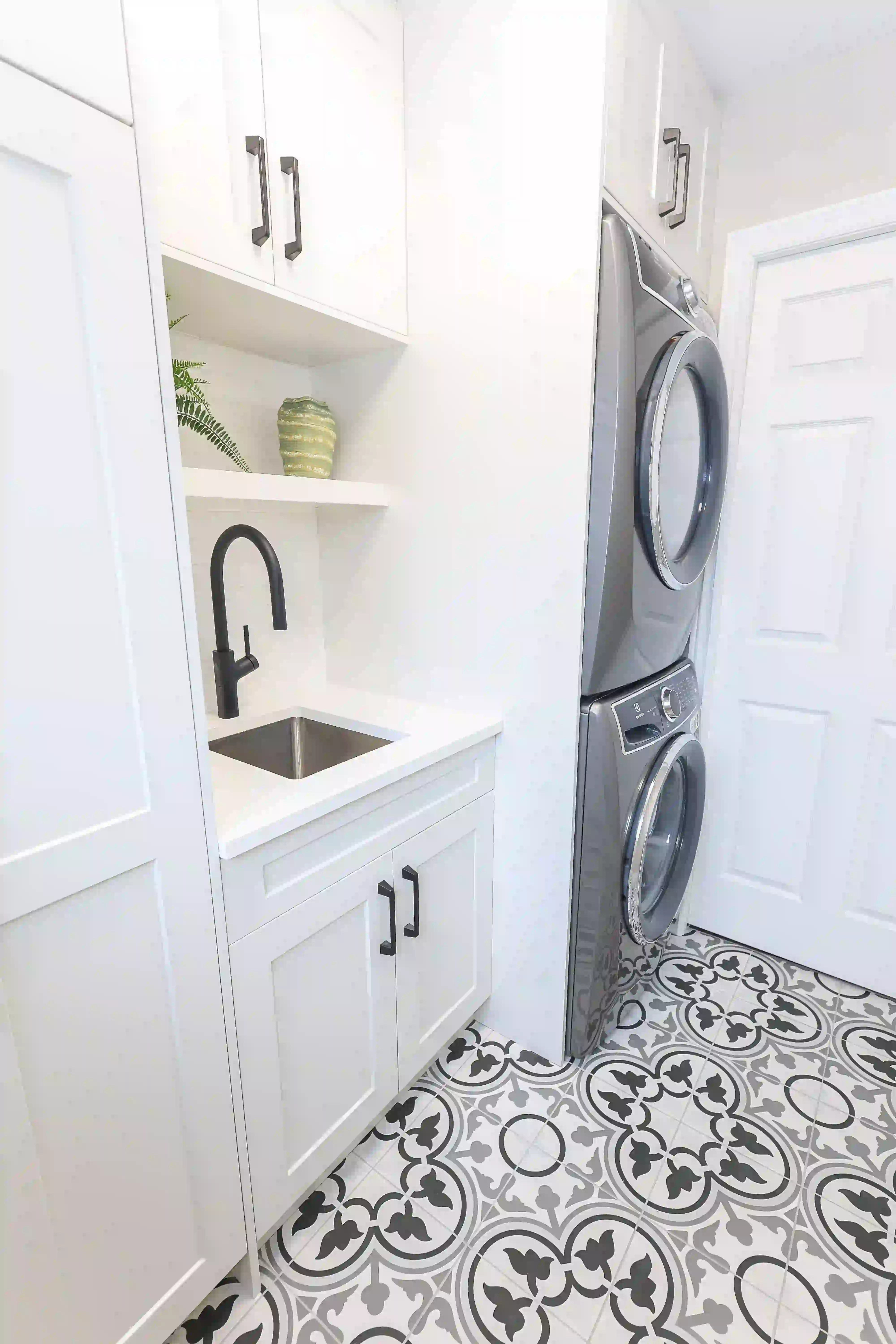 Laundry room sink and stacked appliances