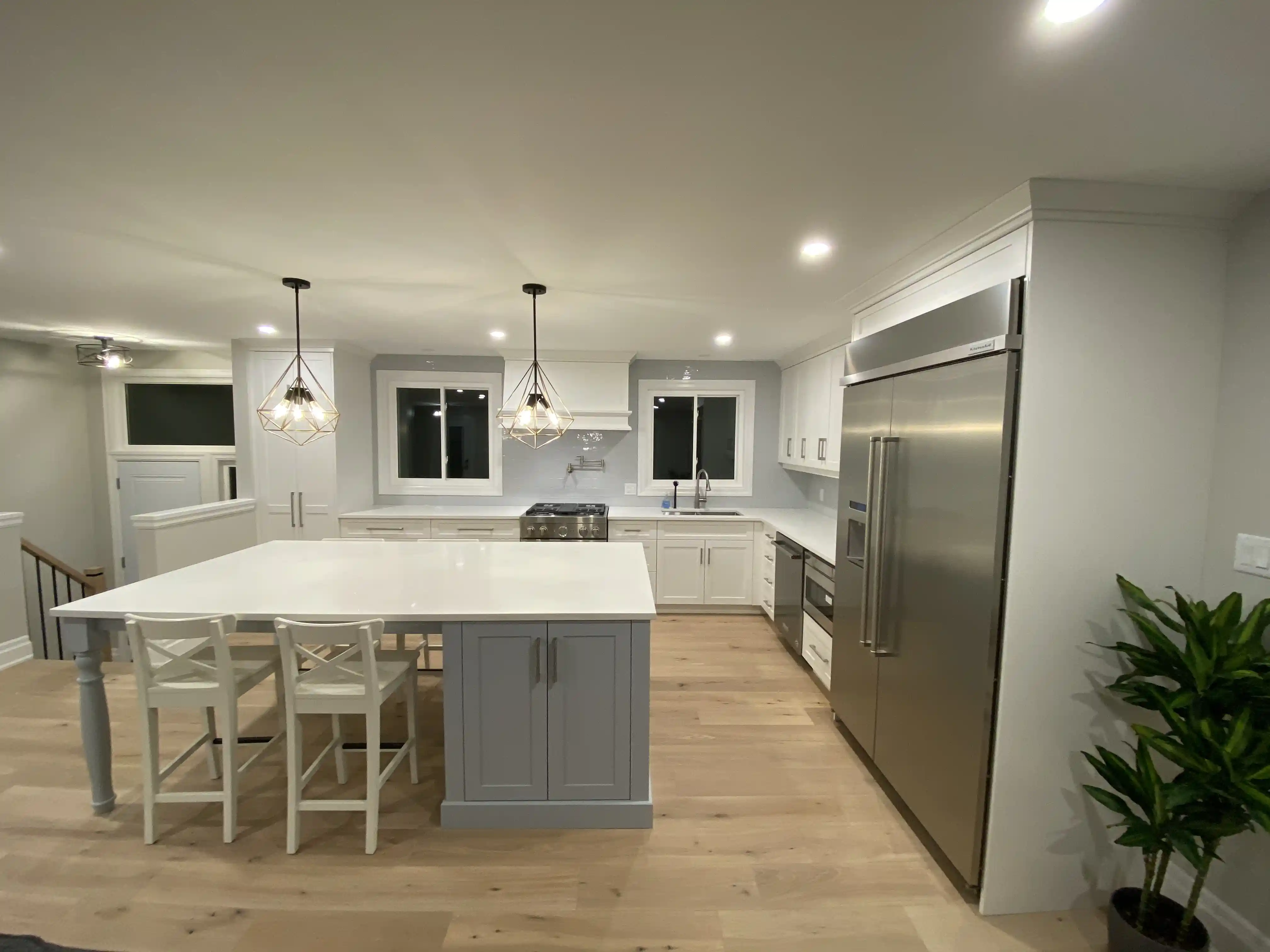White kitchen with island and paneled refrigerator