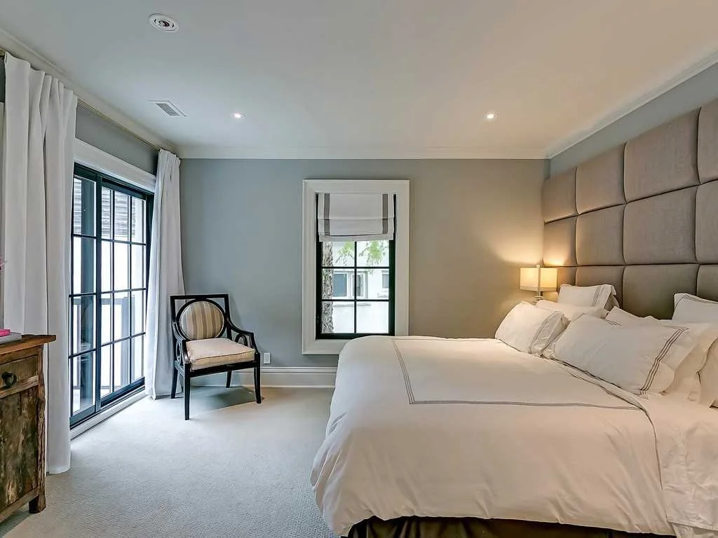 Primary bedroom with paneled headboard wall