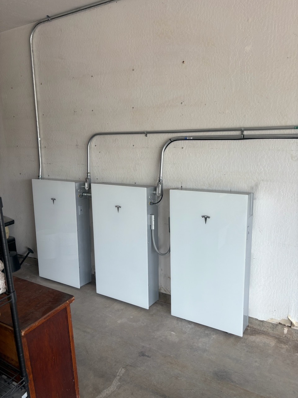Three Tesla Powerwall batteries installed in a garage