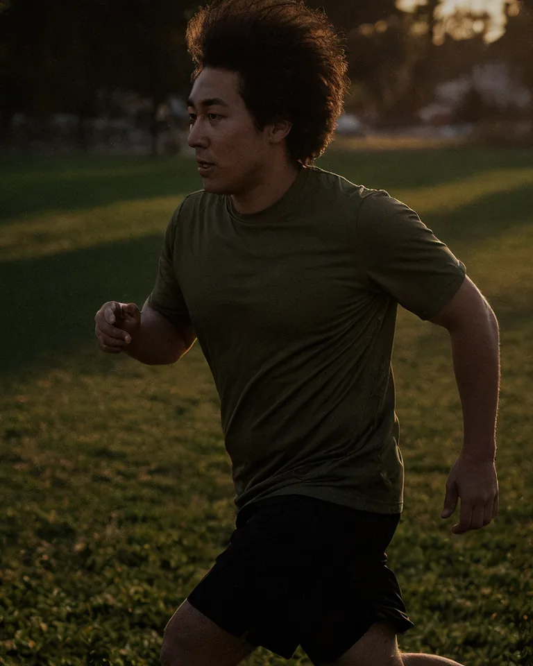 A man runs for the ball in an evening soccer game.