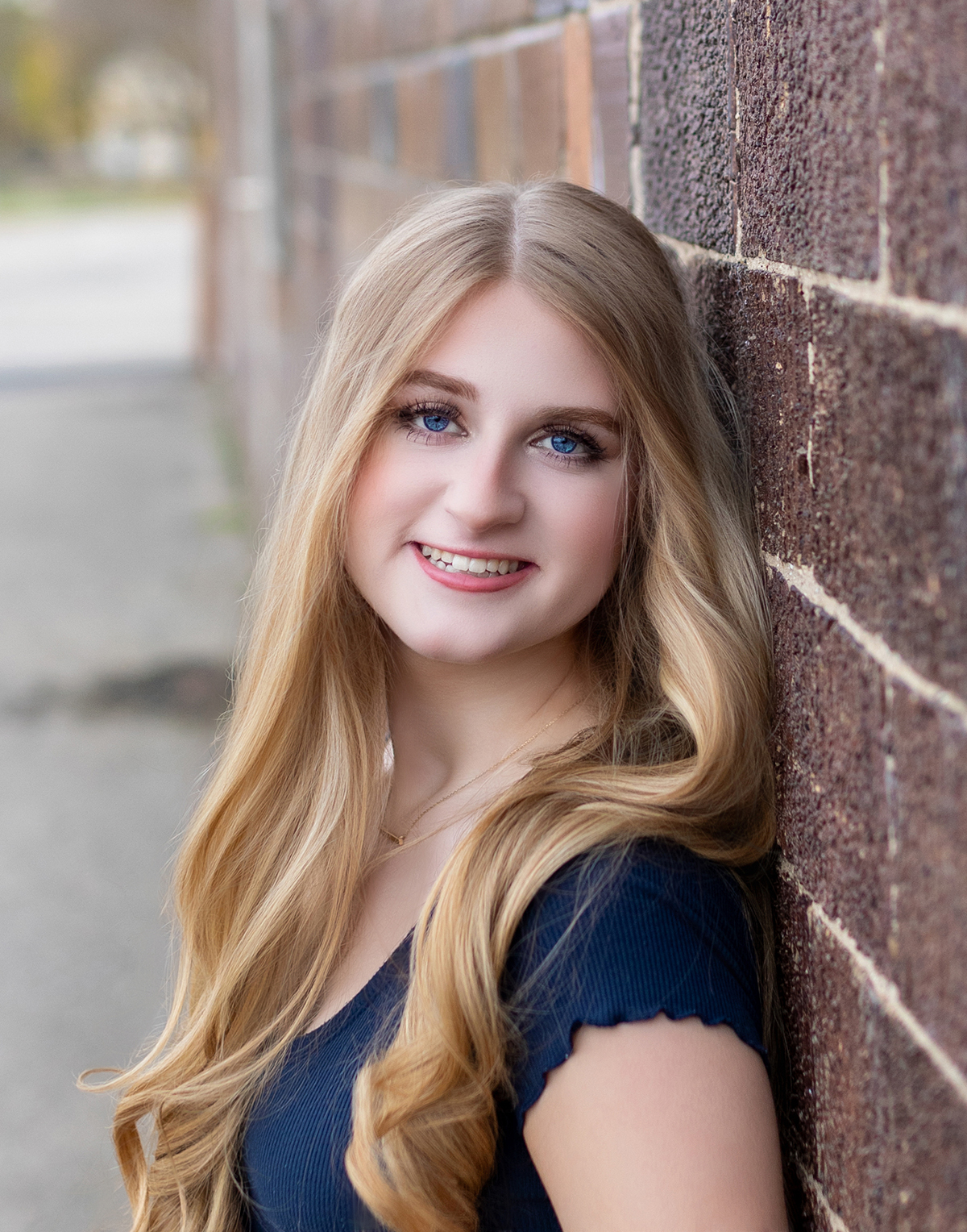 High school senior portrait on brick wall in natural light studio