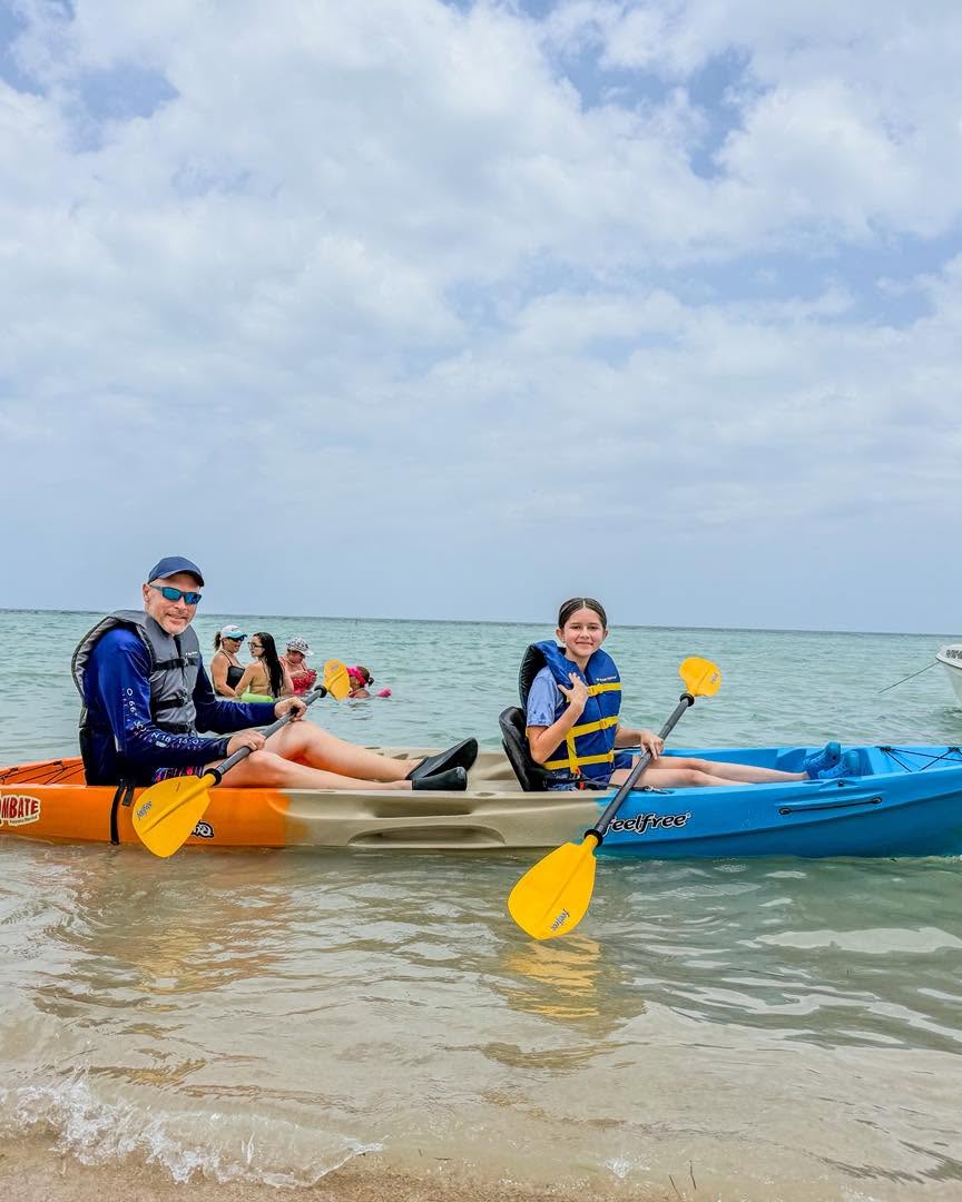 Familia remando en kayak en las aguas cristalinas de Playa El Combate, Cabo Rojo