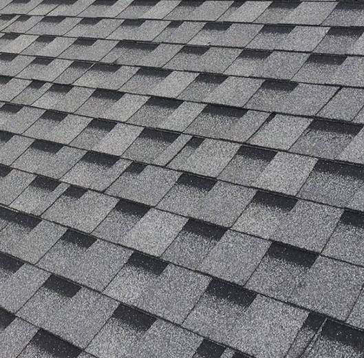 Close-up of a durable, tiled roof under clear skies, representing high-quality roofing solutions provided by Olsen’s Roofing.