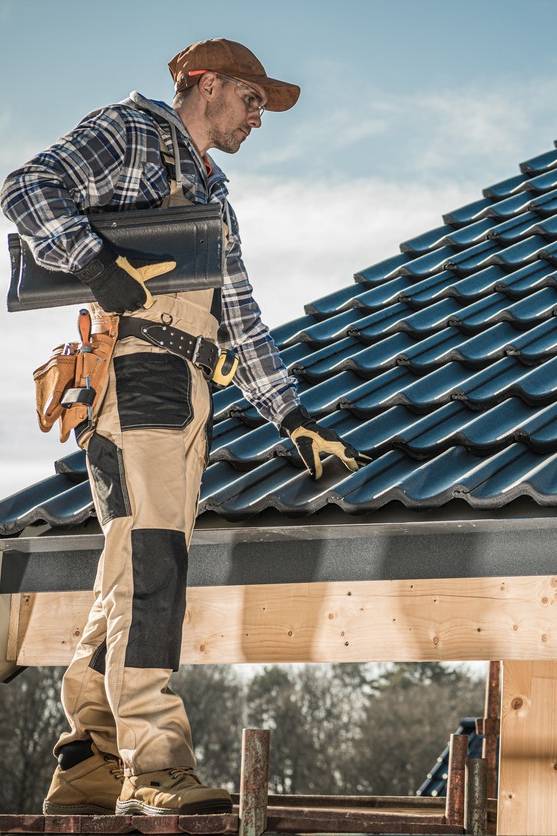 Close-up of a durable, tiled roof under clear skies, representing high-quality roofing solutions provided by Olsen’s Roofing.