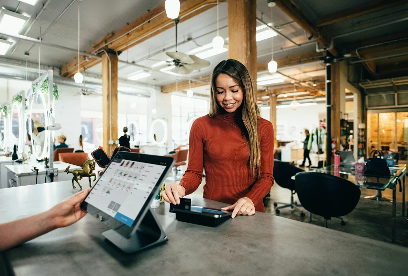 woman using pos to pay for sale
