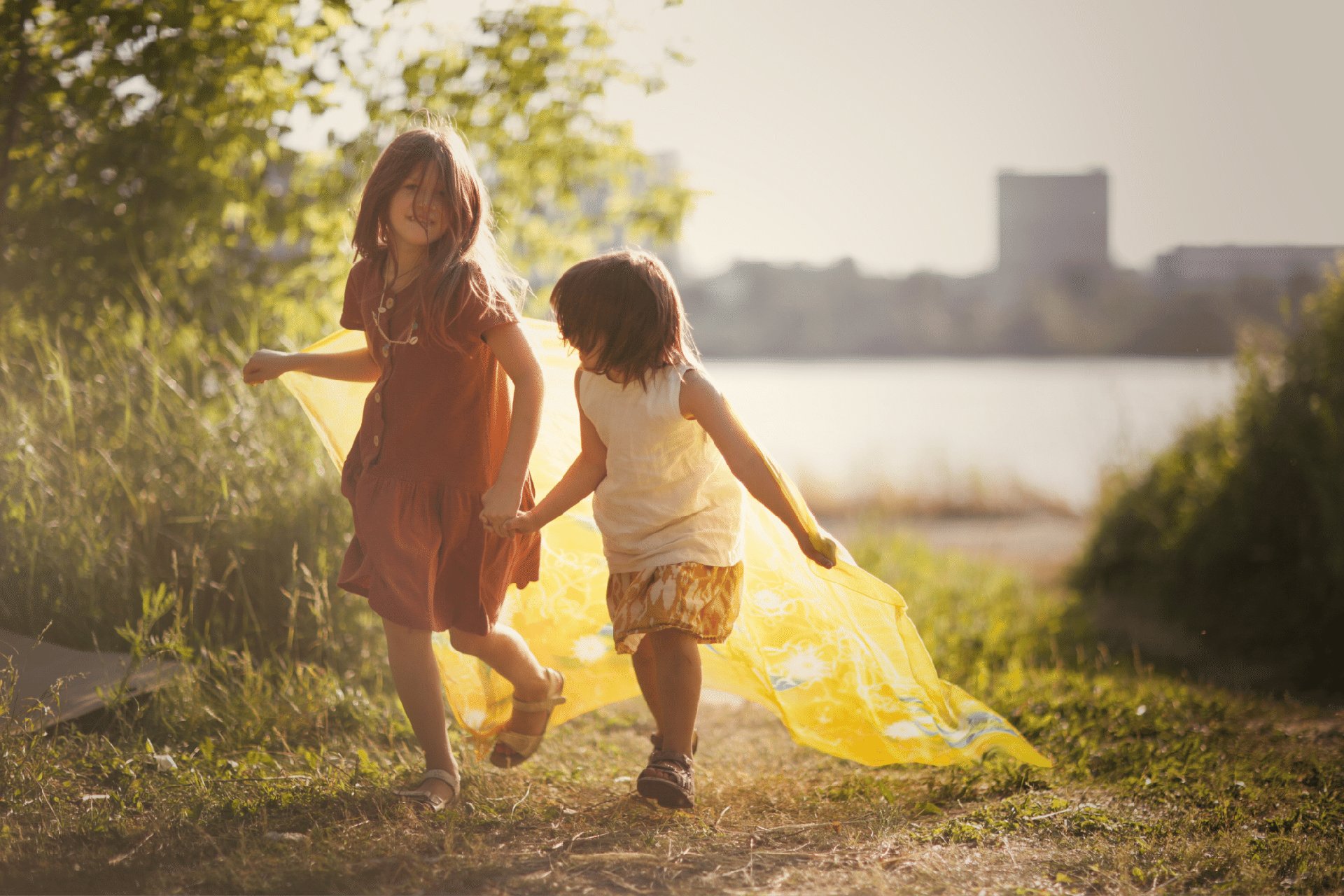Niños corriendo con telas de colores al aire libre