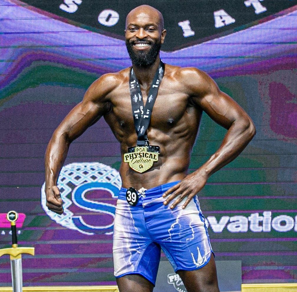 Michael Baptiste on stage wearing the PCA first place medal