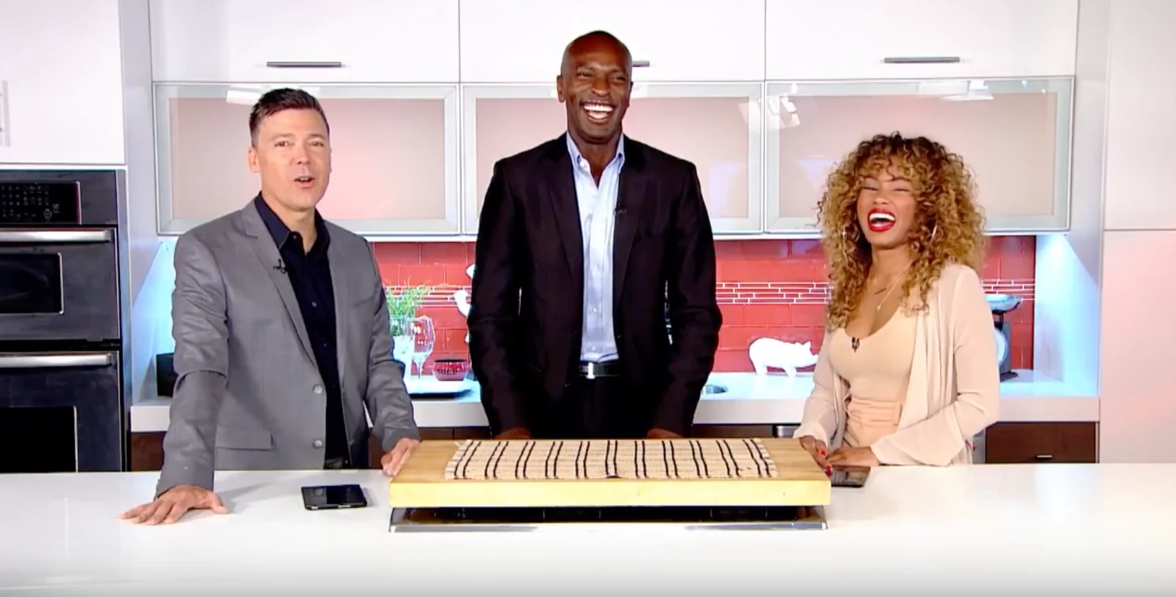 Michael Baptiste on a television kitchen set with two co-hosts