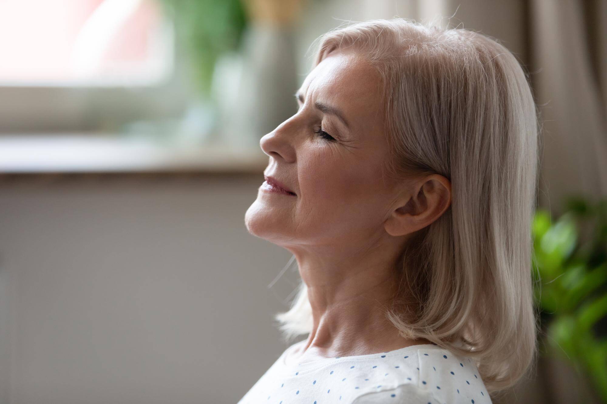 Profile of a silver-haired woman with eyes closed and lips closed, breathing through her nose