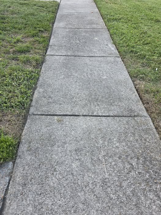 A sidewalk beside a grassy lawn