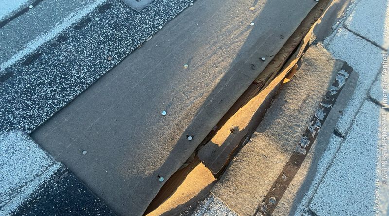 Torn shingle with exposed decking