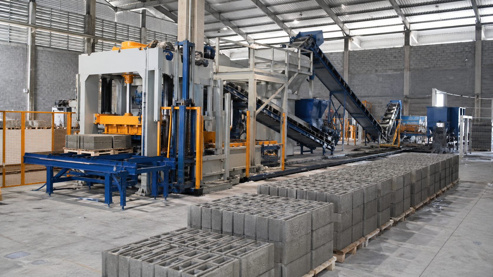 Planta industrial de fabricación de bloques de hormigón en funcionamiento, vista horizontal a nivel de suelo con vibroprensa, cintas transportadoras activas y palets de bloques perfectamente alineados en un entorno limpio y bien iluminado.
