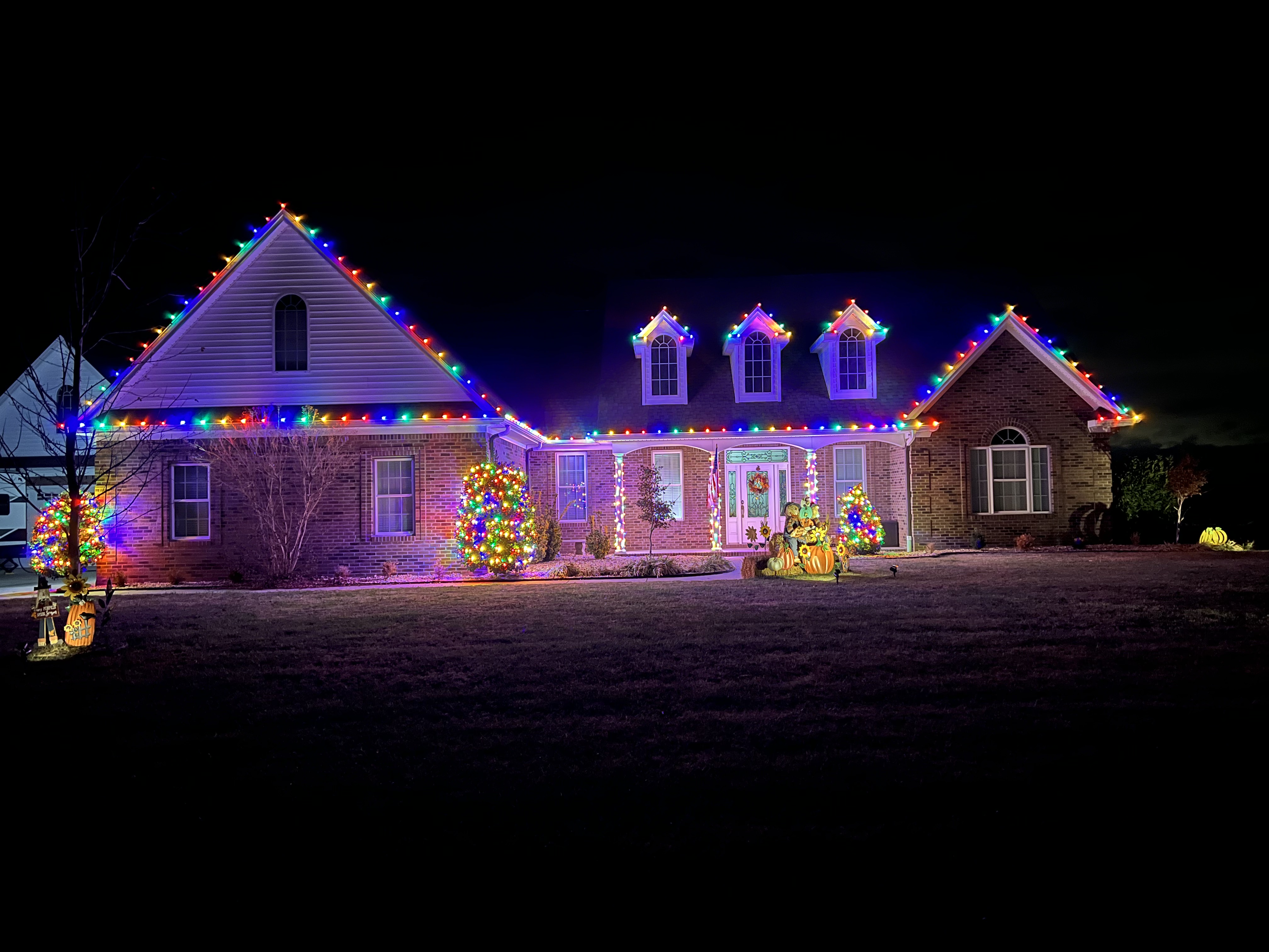 Ranch home with multicolor lights on rooflines and dormers