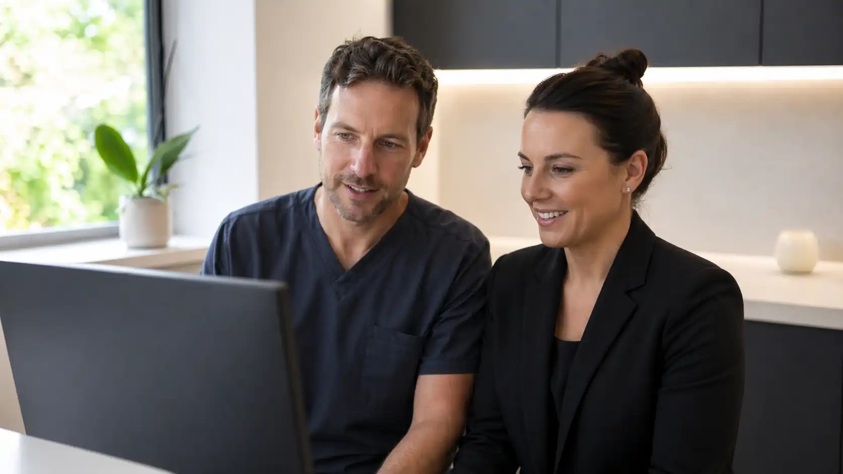 UK private dental practice team reviewing automated recall campaign patient bookings on screen