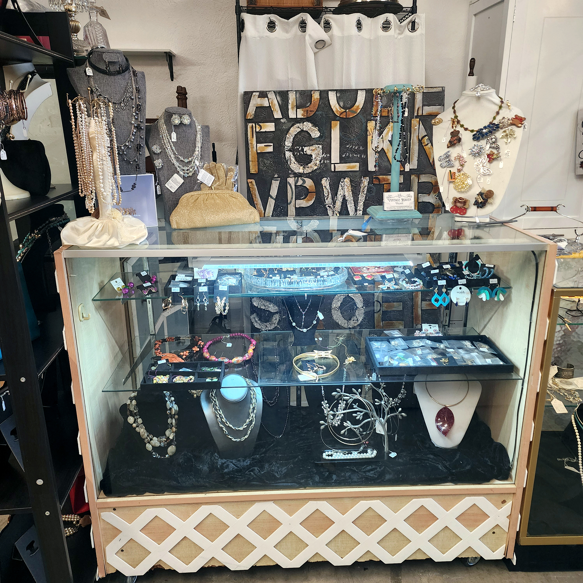 A jewelry display with necklaces, purses, and a glass cabinet