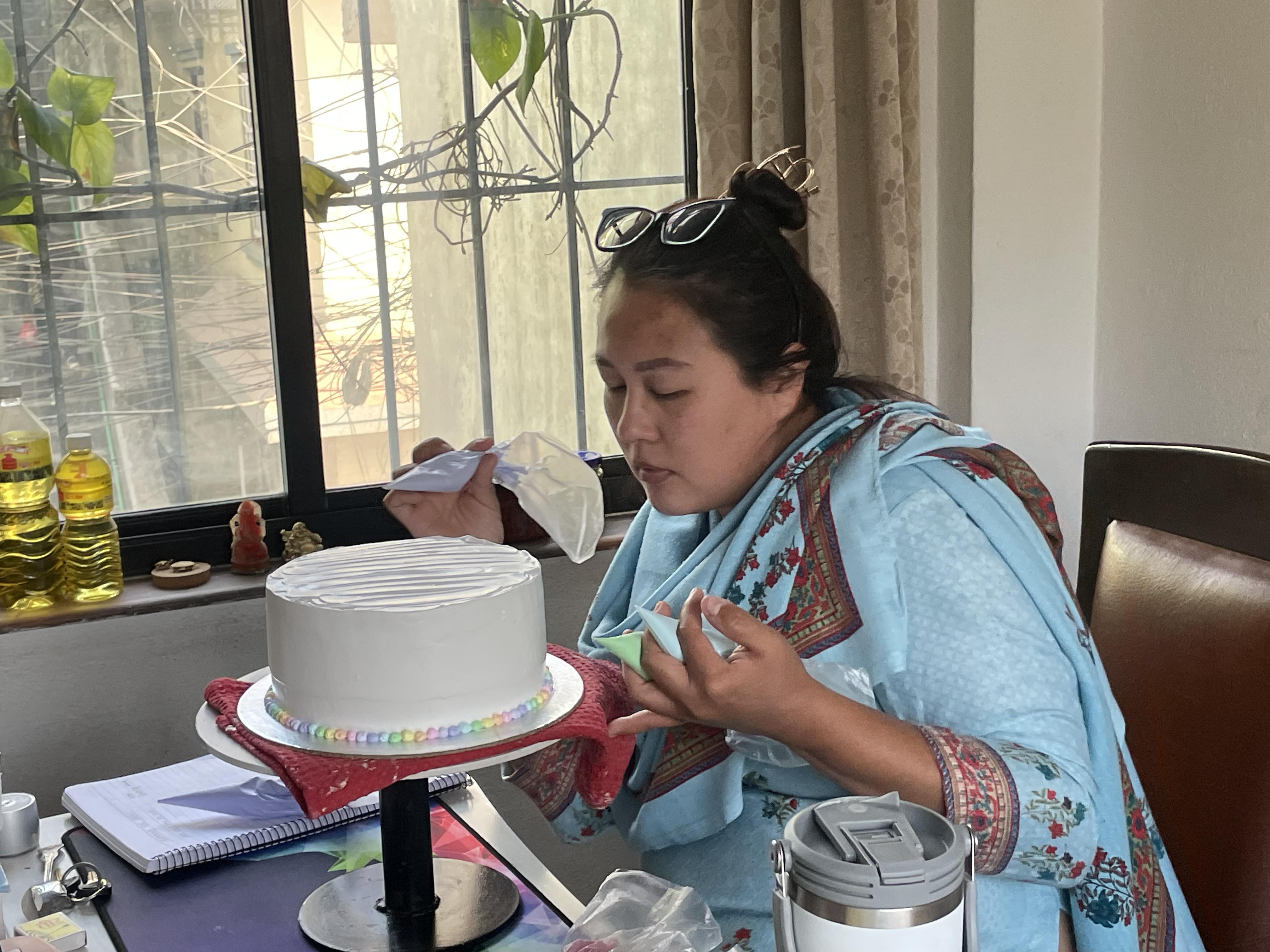 Rainbow layer cake with a slice cut out on a cake stand