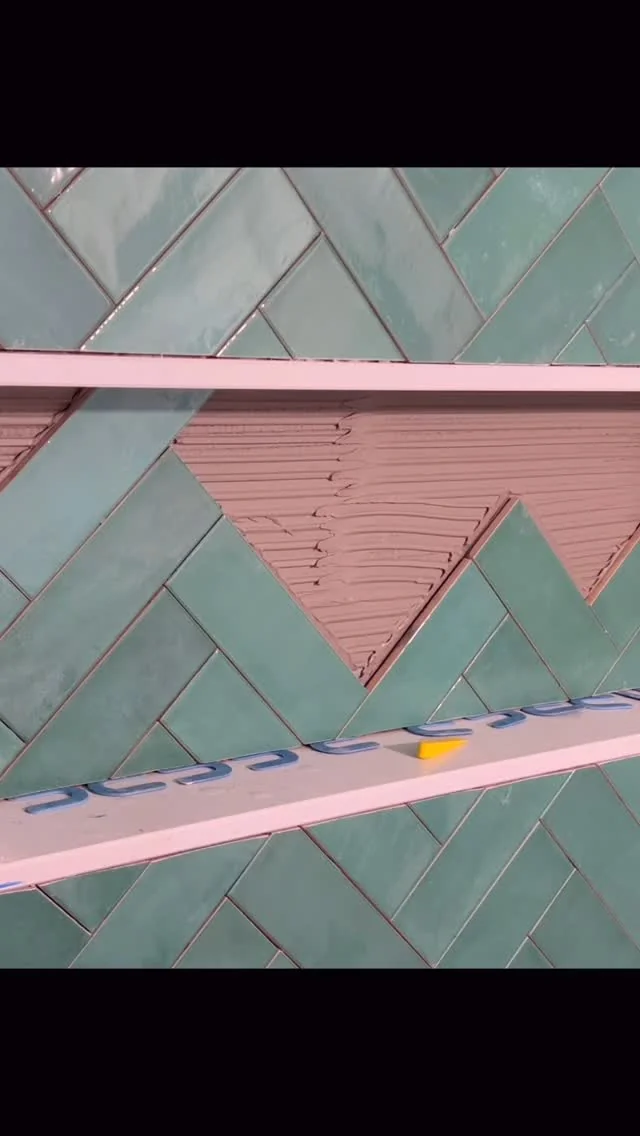 Herringbone green tile installation