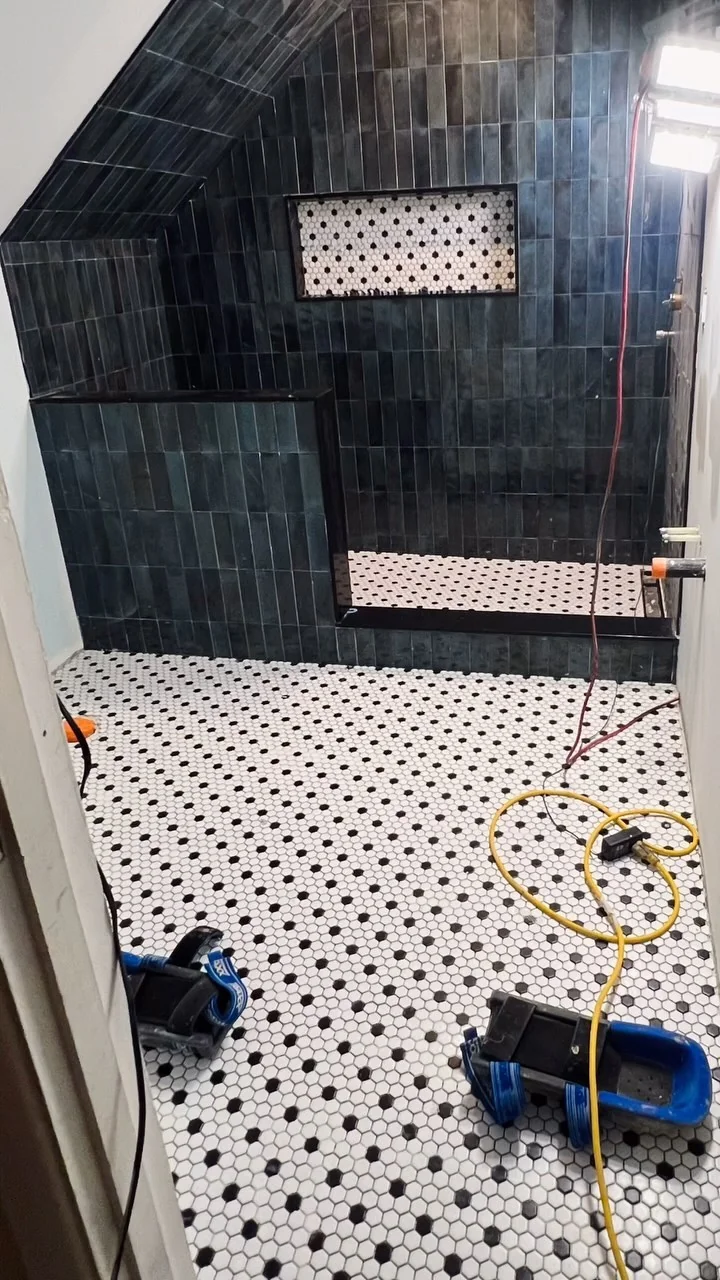 Dark green shower with mosaic floor