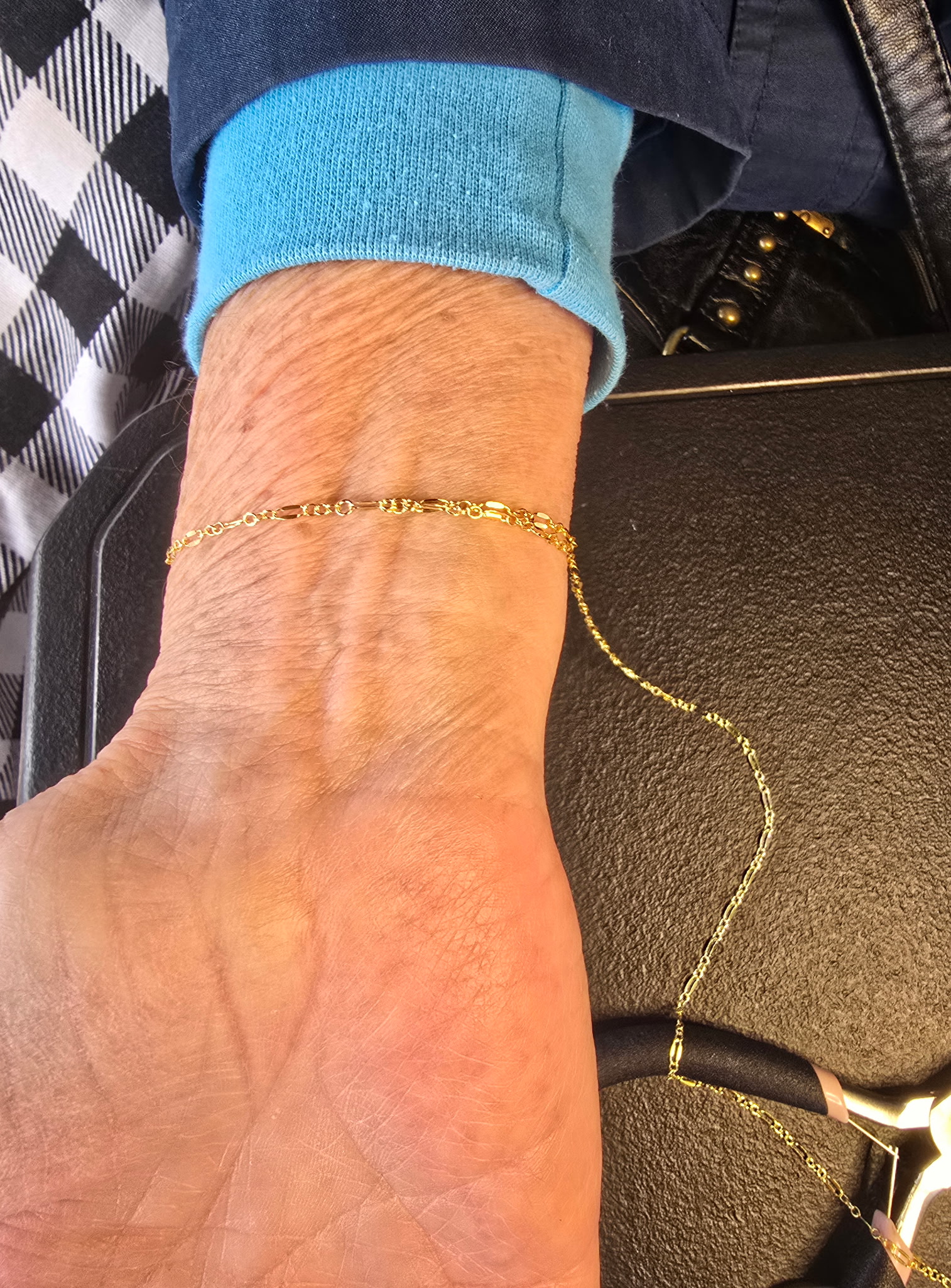 Delicate gold permanent bracelet on a client's wrist, Eternally Linked Bling