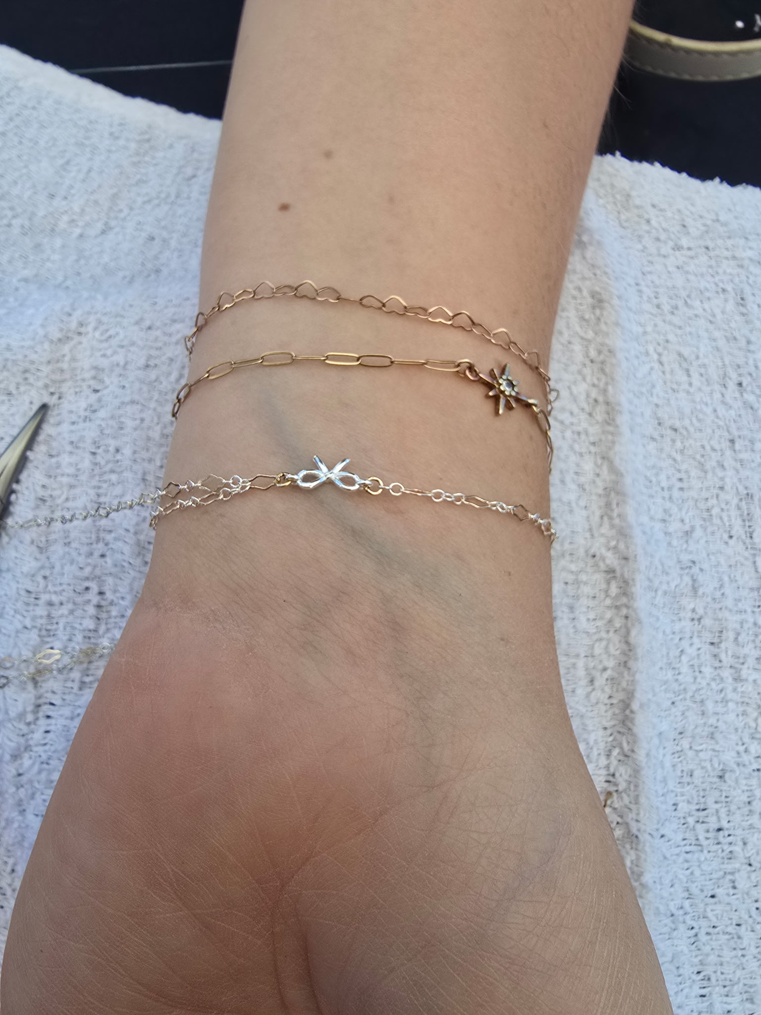 Permanent ankle bracelet chain close up warm lighting skin tone Arizona