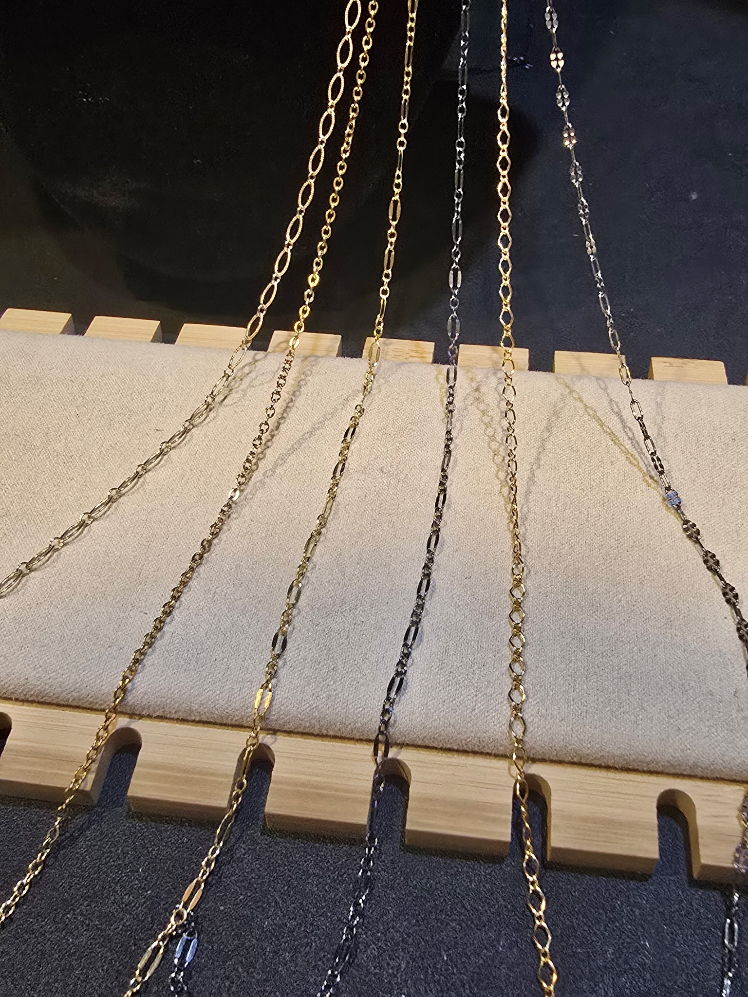 Gold and silver chain styles hanging on display rack permanent jewelry Arizona