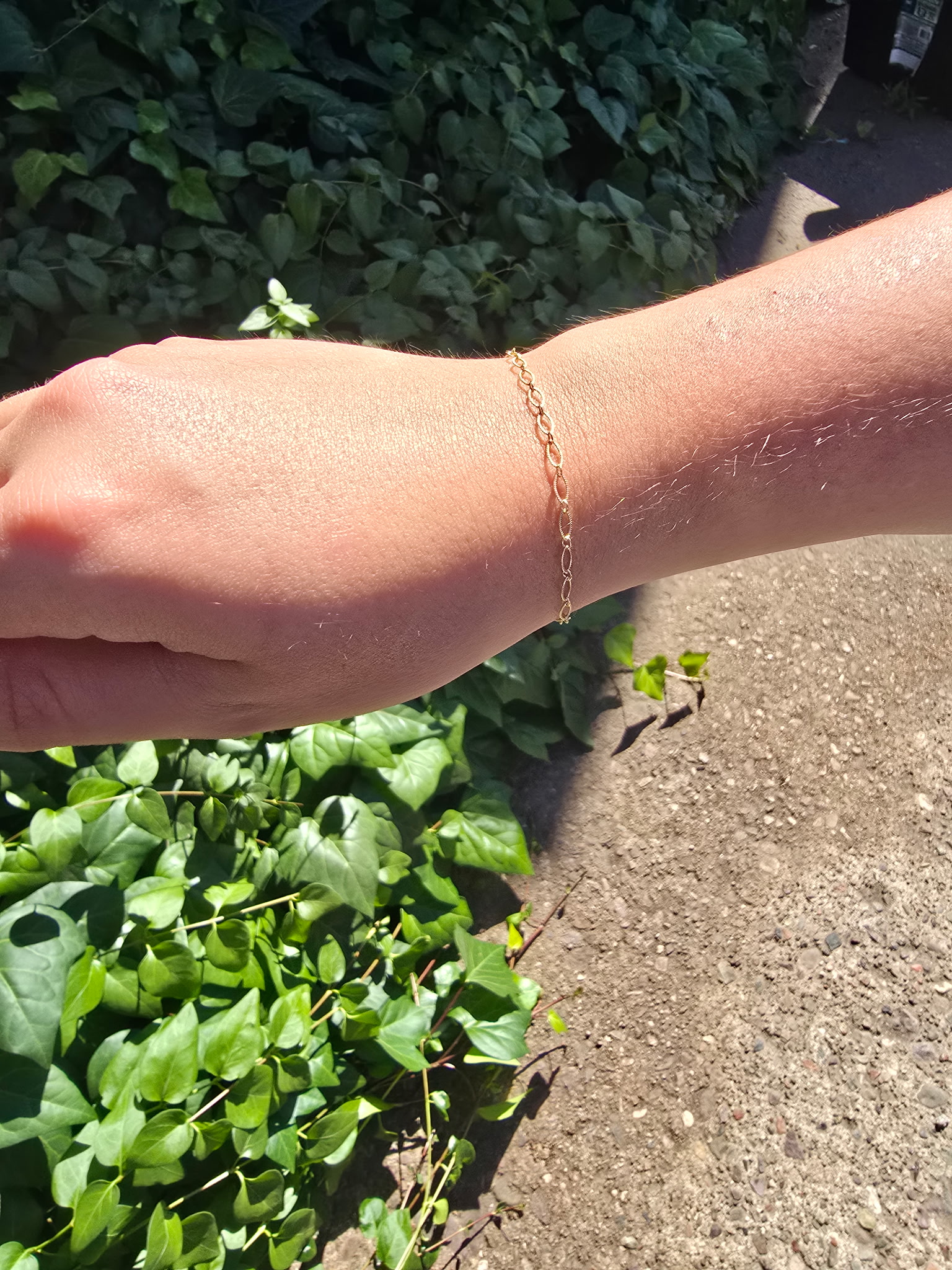 Gold figaro permanent bracelet on wrist outdoors Arizona