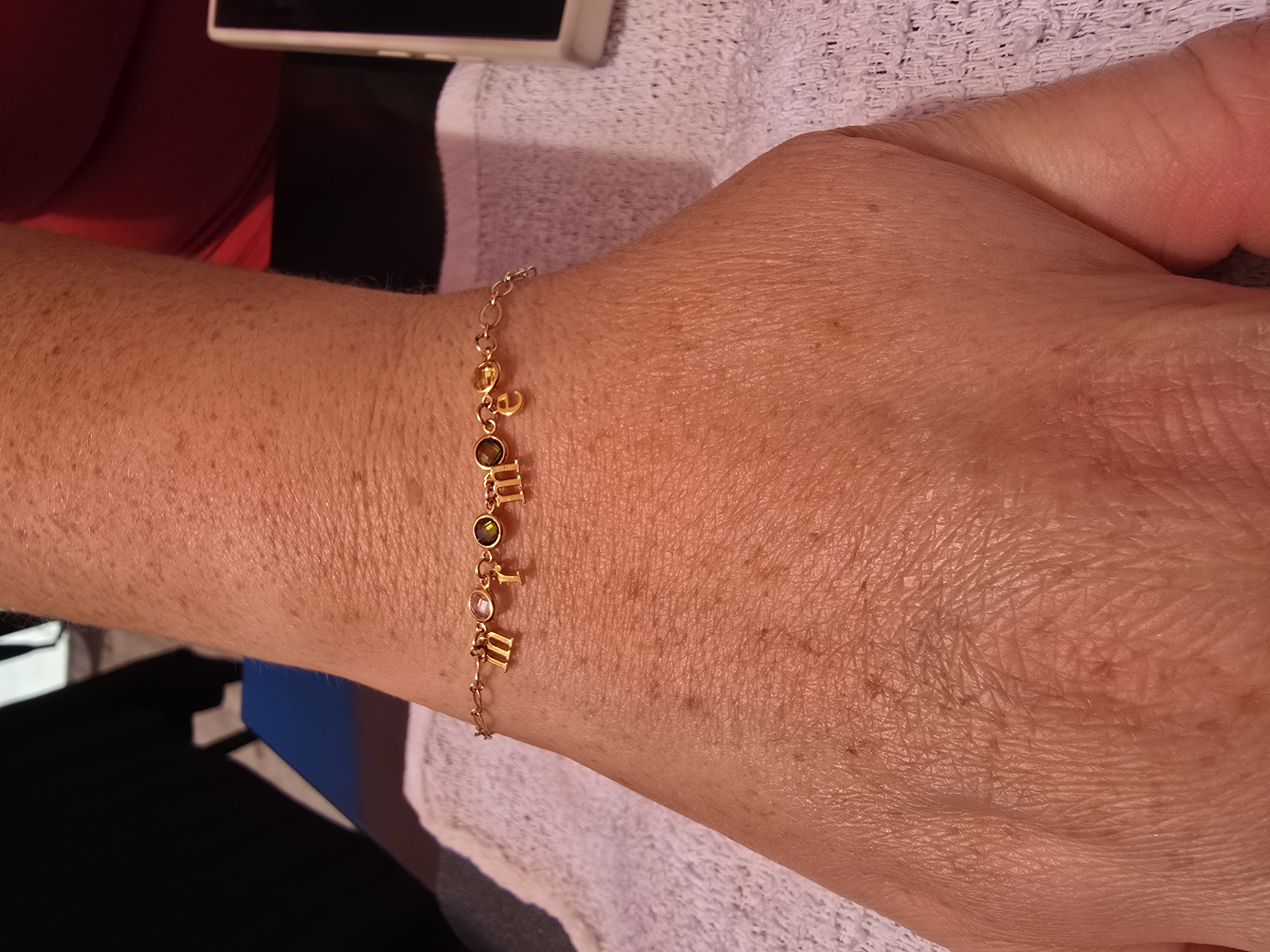 Gold letter charm mother bracelet welded on a wrist Arizona