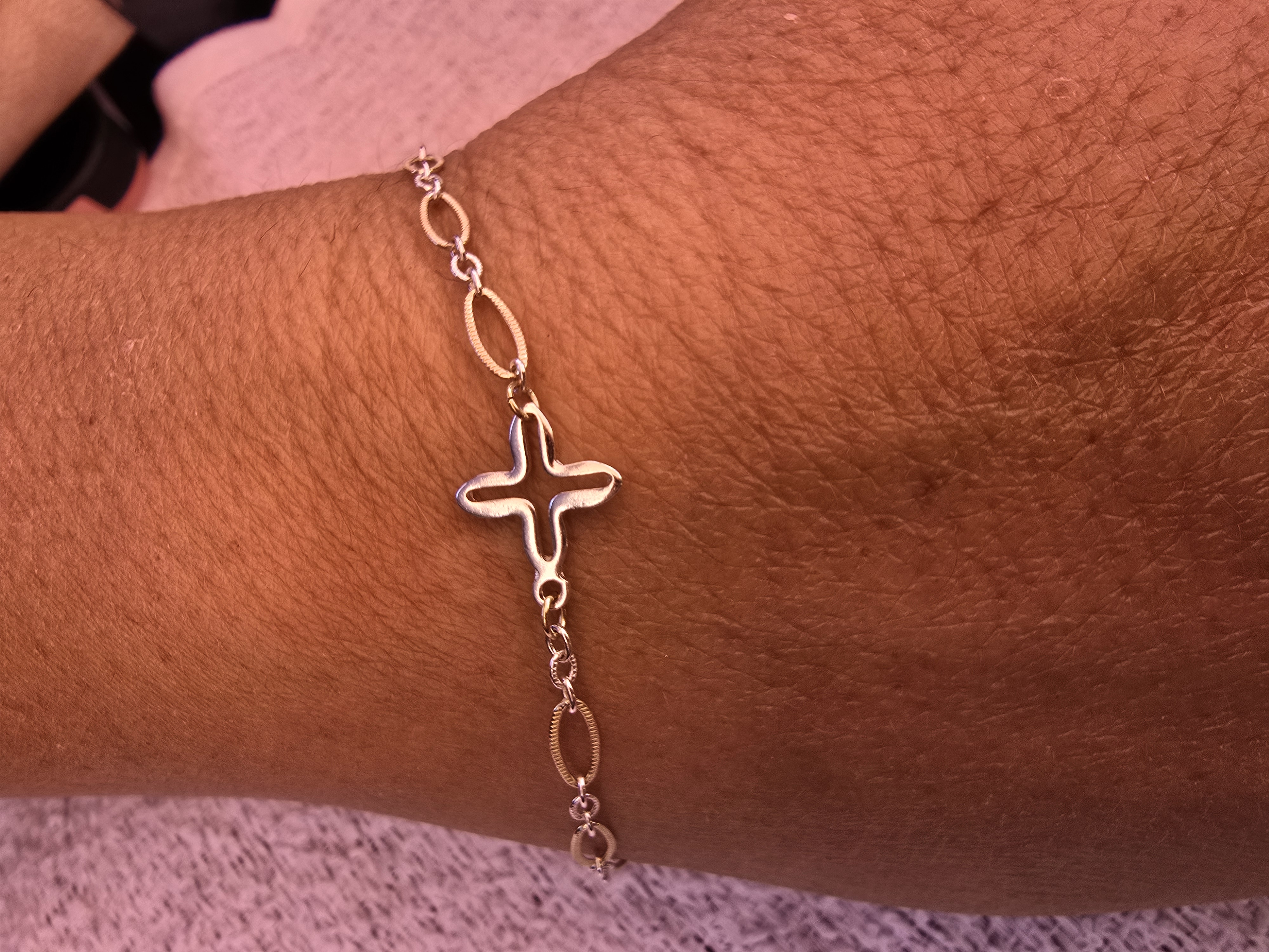 Gold filled permanent bracelet with cross charm welded on a wrist