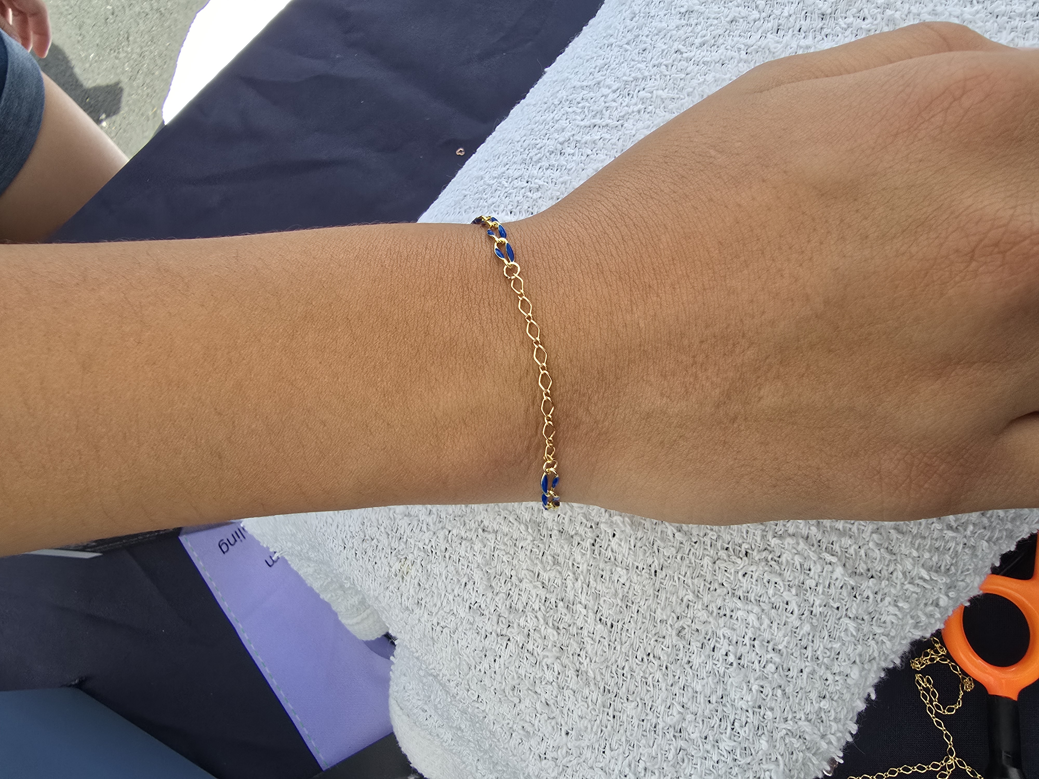 Gold and navy chains mixed into one permanent bracelet on a wrist Arizona