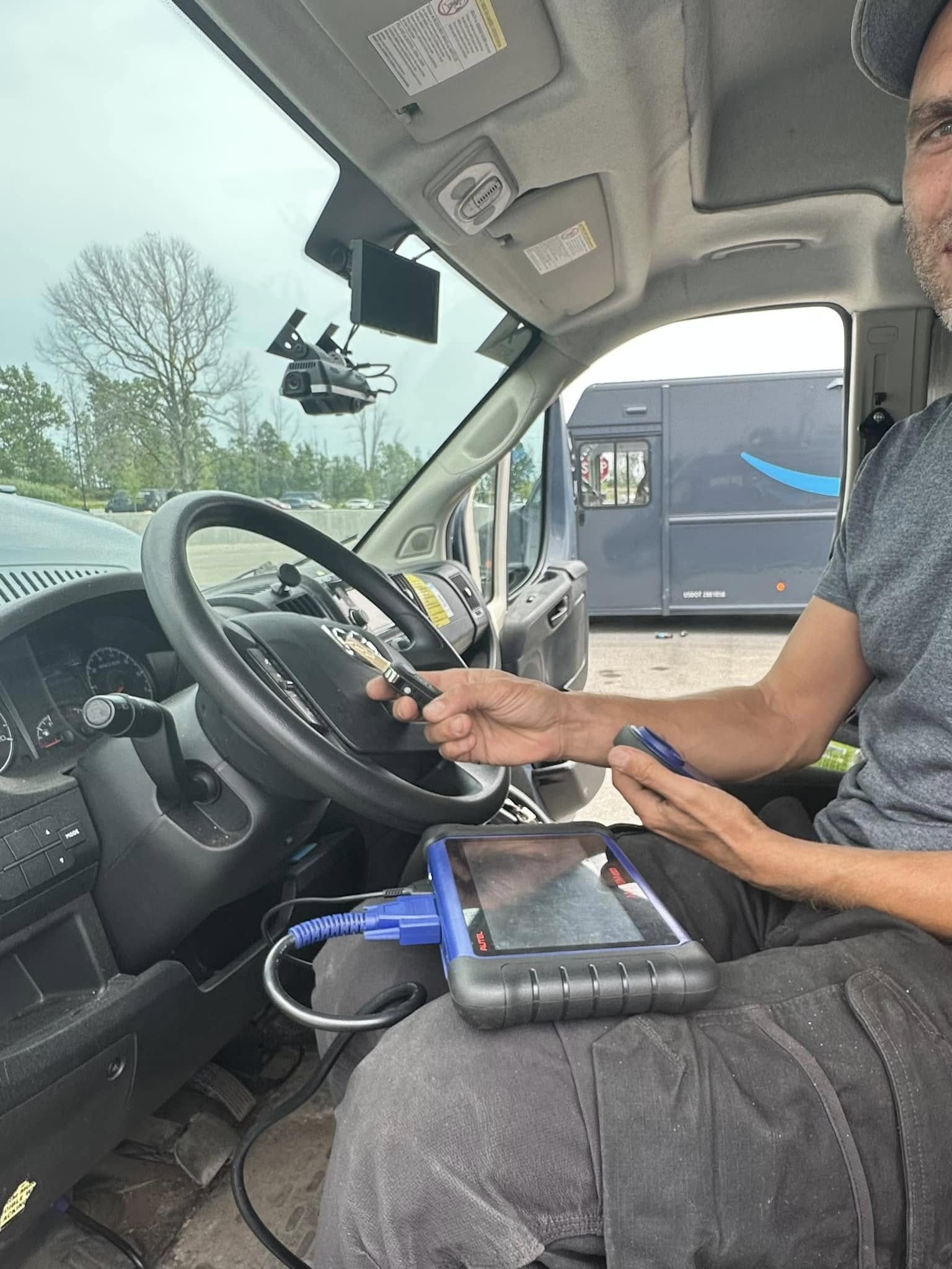 Locksmith programming a car key fob at the customer's vehicle