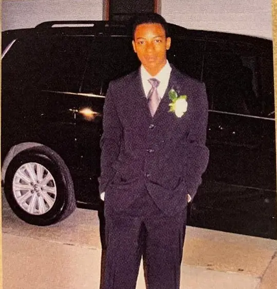Will dressed formally beside a vehicle