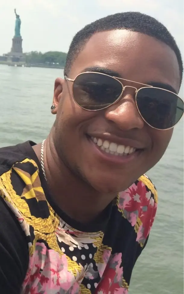 William "Will" Jones smiling near the Statue of Liberty, reflecting his warm personality, kindness, and love for connecting with others.