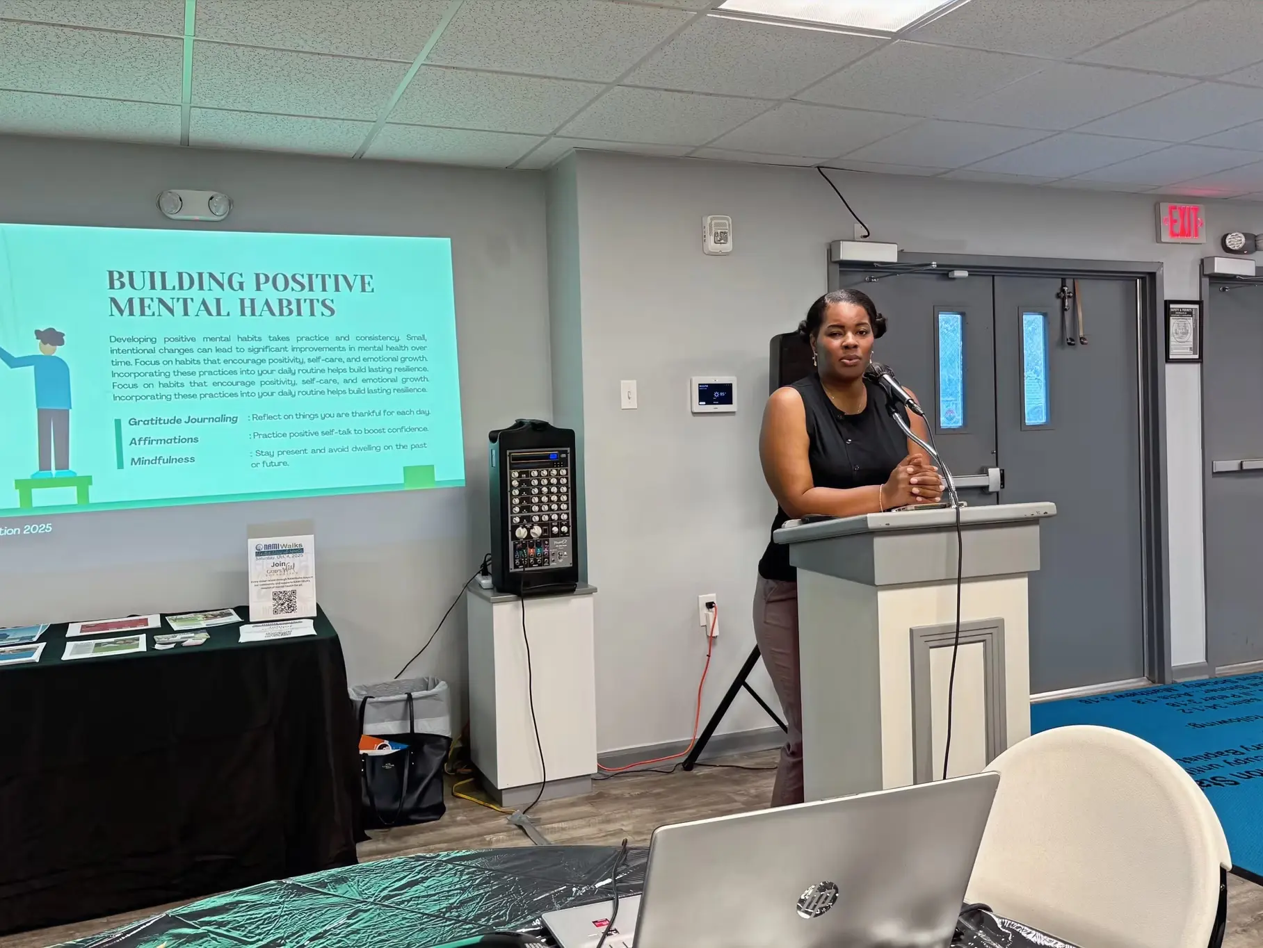 Speaker presenting on mental health awareness at a God's Will Foundation community workshop. 🌿